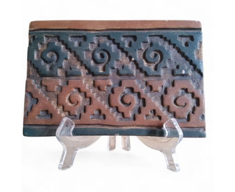 A Pre-Columbian era Aztec terracotta tile, decorated in relief with geometrical banding in ocre and deep blue