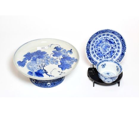 A Japanese ceramic pedestal dish, painted in blue with foliage and animals, together with an early 18th century Chinese blue 