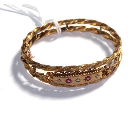 A ruby and diamond hinged bangle, stamped '9CT'.  Gross weight 11.17 grams 