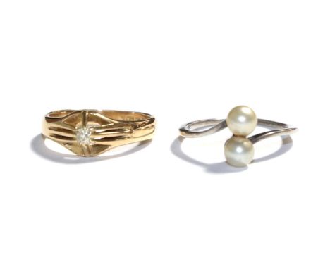An 18 carat gold diamond solitaire ring, finger size M1/2; and a cultured pearl twist ring, indistinctly stamped, out of shap