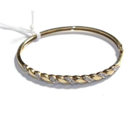 A 9 carat gold diamond hinged bangle .  Gross weight 9.78 grams.