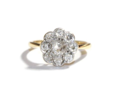 A diamond cluster ring, stamped '18CT&amp;PT', estimated diamond weight 0.70 carat approximately, finger size K.  Gross weigh