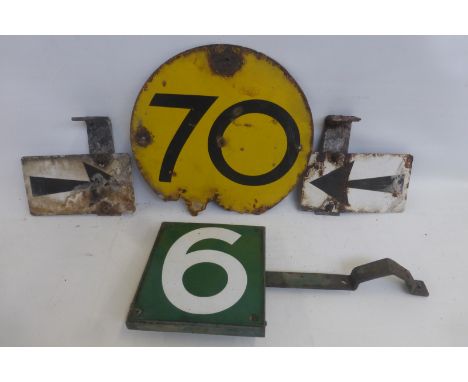 A green and white enamel no. 6 sign with bracket and wooden backing, a circular yellow speed indicator for 70 and two enamel 