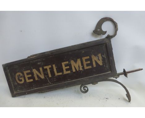 A station platform double sided wooden sign for Gentlemen on a wrought iron bracket.