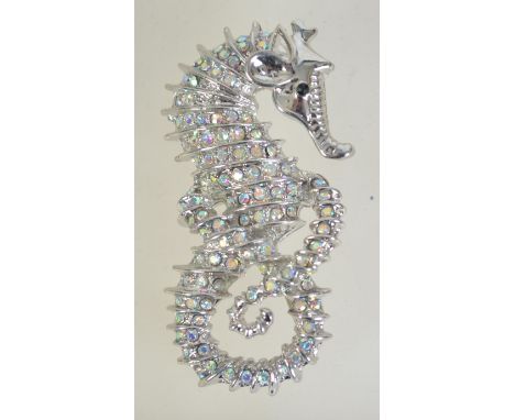 A silver tone figural brooch pin in the form of a seahorse set with AB rhinestones with roller clip clasp. Measures 6cms.