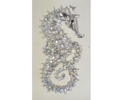 A silver tone figural brooch pin in the form of a seahorse set with AB rhinestones with roller clip clasp. Measures 6cms.