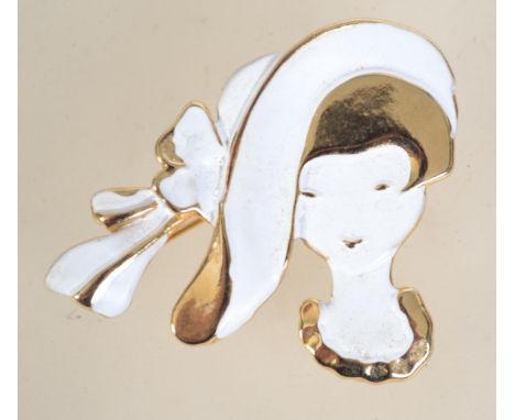 A vintage gold tone and enamel brooch in the form of a lady with roller clip clasp. Measures 5 cms.
