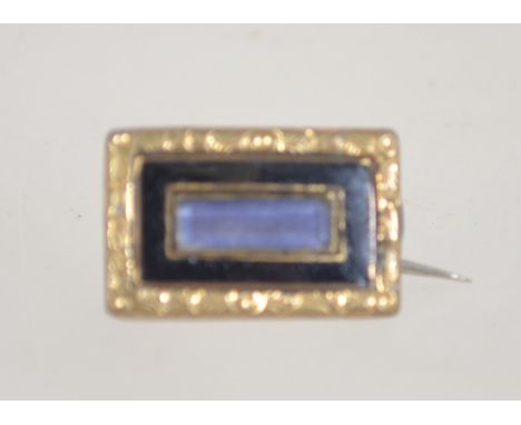 A Victorian mourning brooch with black enamel and yellow metal gallery with c clasp. Measures approx .7cms x 1.5cms.