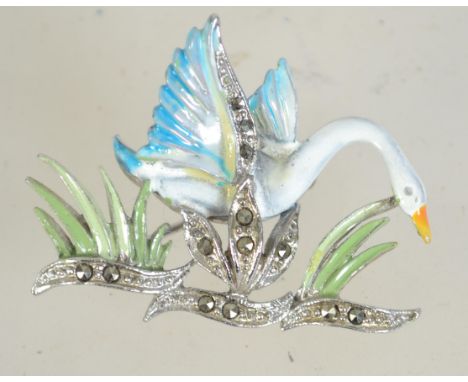 A vintage silver tone and enamel brooch in the form of a swan in flight with marcasite set reeds and roller clip clasp. Measu