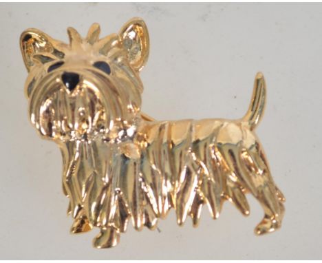 A vintage gold tone and enamel brooch in the form of a terrier dog with roller clip clasp. Measures 3.5 cms.