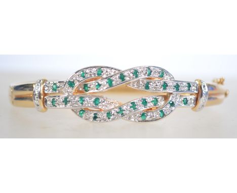 A gilt silver hinges bangle set with emeralds with box clasp. Weighs 25 grams measures 6.5cms.