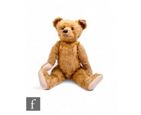 A mid 20th Century Farnell mohair hump back teddy bear, glass eyes, cloth pads, with growler, length 70cm.