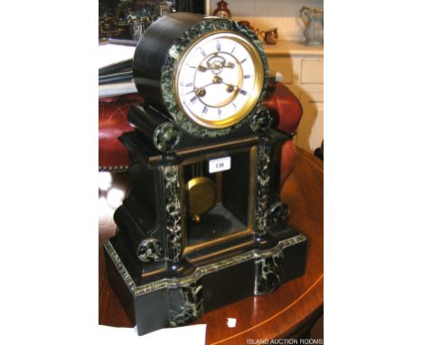 A large slate and marble mantel clock with visible escapement
