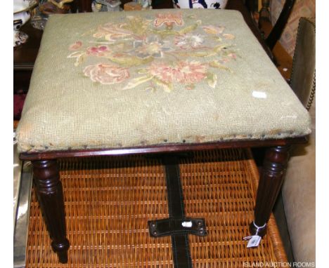 An antique footstool with reeded legs and tapestry top