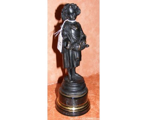 A bronzed figure of a girl playing a hurdy-gurdy set on porcelain base - 28cm high