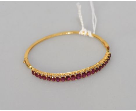 A ruby set bangle, the 21 vari-cut rubies totaling approx. 4.55cts.