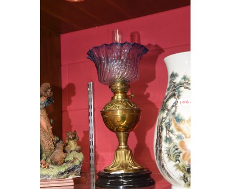 A Victorian brass oil lamp with frilly and fluted blue glass shade & glass funnel and on circular black ceramic base, height 