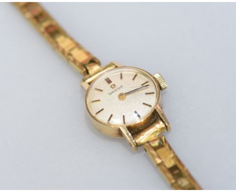 An Omega ladies' wristwatch with circular face and baton numerals, with gold plated strap