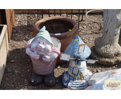 A garden ornament in the form of a windmill; a plant pot decorated with a gnome and one other planter 