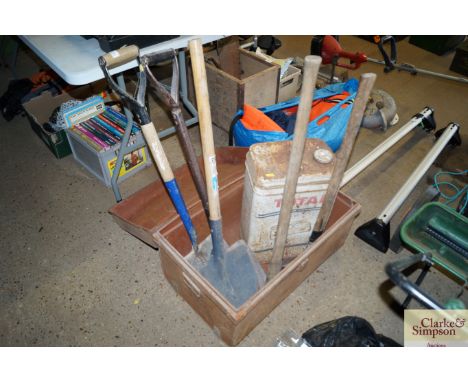 A tin trunk and contents of long handled gardening tools 