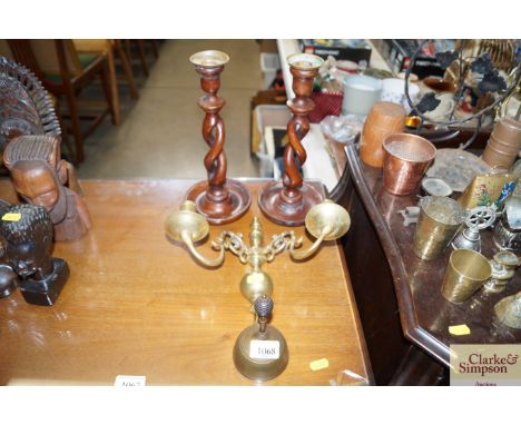 Two wooden candlesticks together with a brass wall light fitting and brass bell