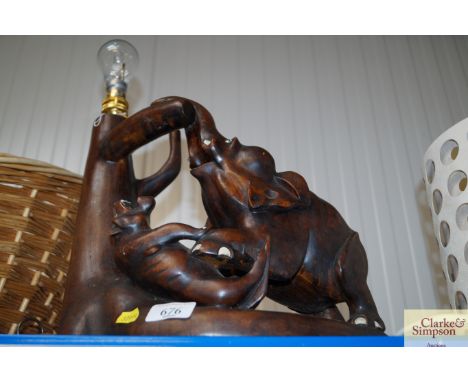 A wooden table lamp depicting animals fighting (AF)