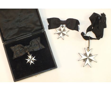 A white metal and enamel collarette for The Order of St John of Jerusalem and two breast badges on black ribbon bows, (3).