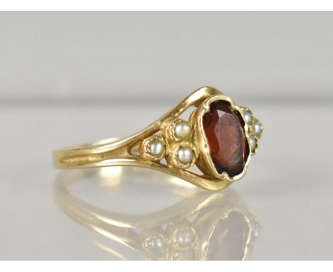 A 9ct Gold, Garnet and Seed Pearl Ladies Ring, Oval Cut Garnet Measuring 6.5mm by 4.25mm, Set in Crimped Collet and with Two 