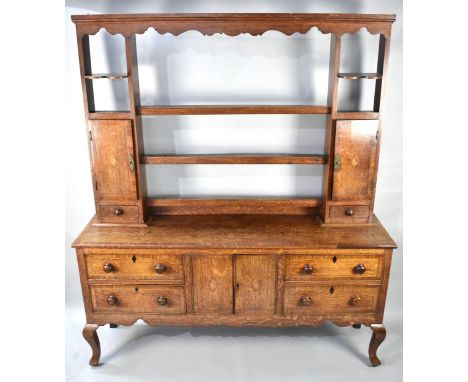 A George III Oak Crossbanded Dresser Having Open Plate Rack with Three Central Shelves Flanked by Two Cupboard Doors with She