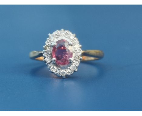 A ruby &amp; diamond set 18ct gold oval cluster ring, Birmingham marks.  Finger size M.