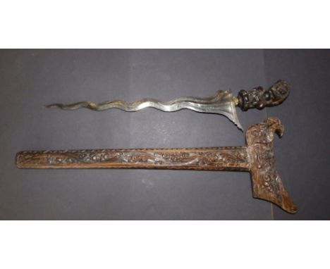 A 19thC kris, having elaborately carved wooden hilt &amp; scabbard, engraved decoration to  the 15" blade with traces of gild