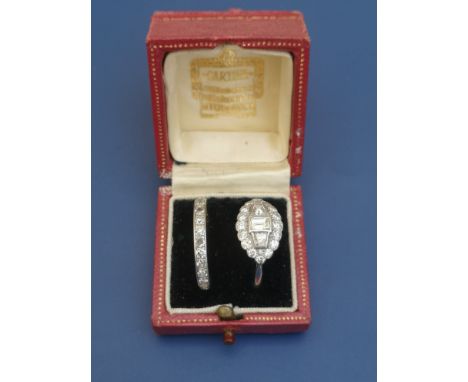 A Cartier ring box containing an Edwardian diamond set platinum cluster style ring, the shank numbered '8152', finger size Q/