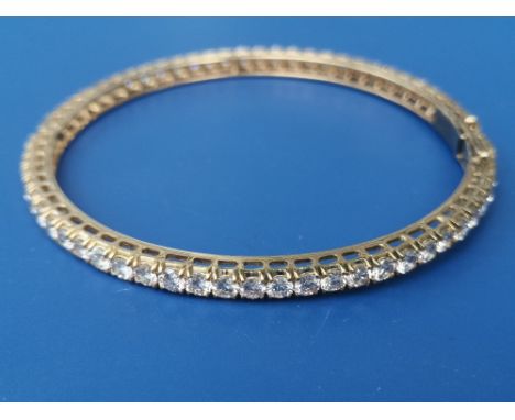 A diamond set bangle, having 63 brilliant cut stones of total weight approximately 7.5 carats - tests as 18ct, maximum intern