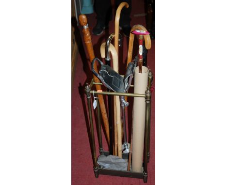 A brass and cast iron six division stick stand with sundry contents