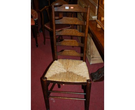 A set of four early 20th century oak ladder back rush seat dining chairs Condition Report / Extra Information Two of the rush