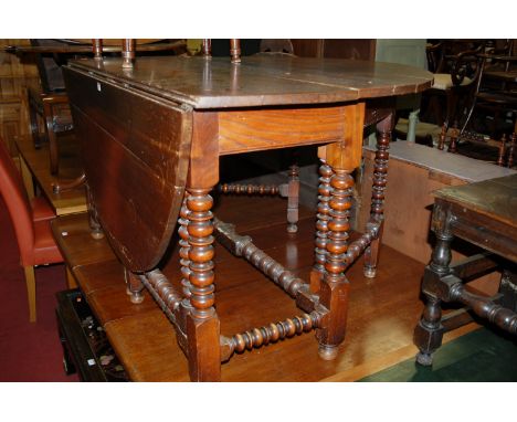 An 18th century joined oak and walnut drop leaf dining table having a double gateleg action and raised on bobbin turned and s