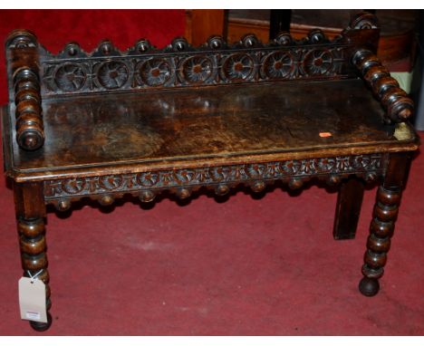 An early 20th century moulded oak ledgeback hall seat, raised on bobbin turned forelegs, width 90cm