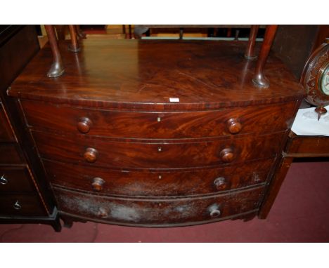 An early 19th century mahogany bowfront chest of four long graduated drawers, each having turned wooden knobs and raised on b