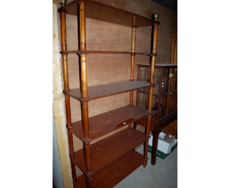 A large reproduction mahogany free standing six-tier open display shelf having turned columns, width 104 cm