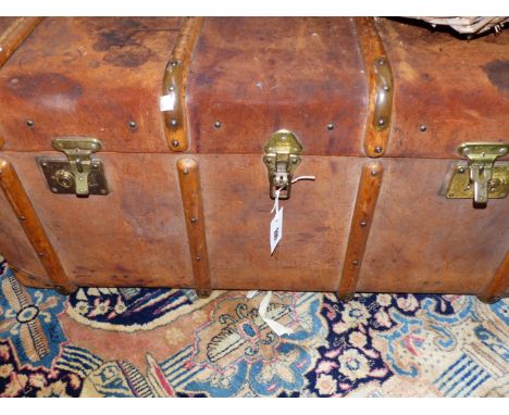 A LARGE WOOD BOUND LEATHER TRAVELLING TRUNK.