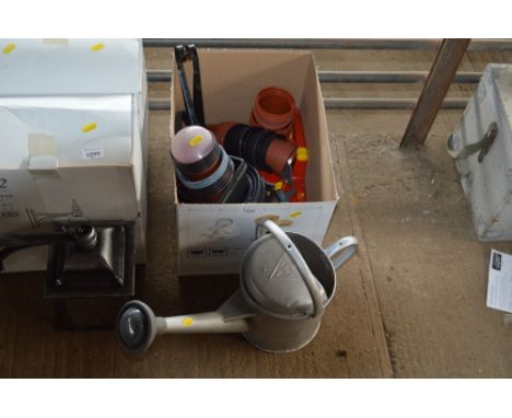 A watering can together with a box containing plastic planters and gardening tools etc.