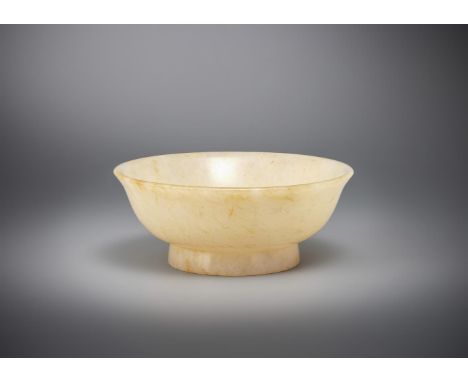 A Chinese small pale celadon and russet jade bowl, Qing dynasty, on raised circular foot with flared rim, the base with incis