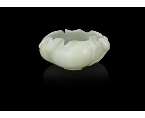 A Chinese carved celadon jade water pot, Qing dynasty, carved in openwork, depicting a peach with roll-form edges and branchi