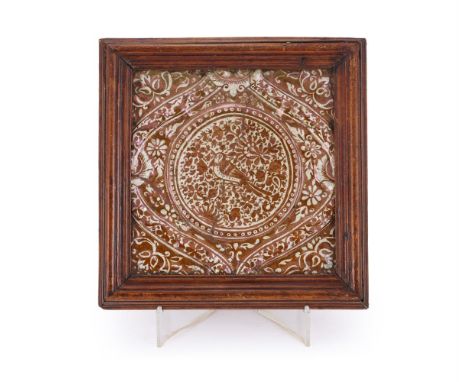 A Qajar lustreware moulded tile, Persia, 19th century, moulded in relief with a round boss decorated with a bird perched with