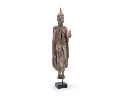 A carved and painted wood figure of Buddha, Thailand, standing with left hand raised in abhaya mudra, his right at his side, 