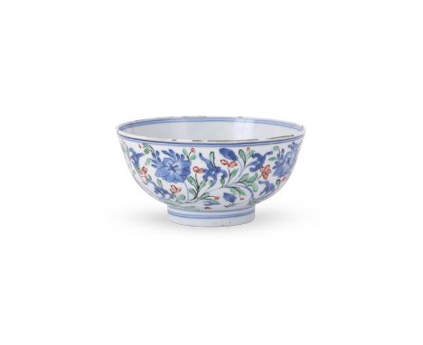 A Chinese blue and white bowl, Kangxi, painted in underglaze blue with scrolling flowers and foliage, over decorated with gre
