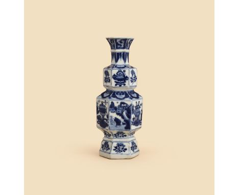 A Chinese blue and white vase, Kangxi, of hexagonal form, painted with landscapes and precious objects, floral borders, 24 cm