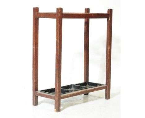 A 1920s century oak umbrella hallway stick stand. Rectangular form with six sectioned top. With ebonised metal drip trays. Su