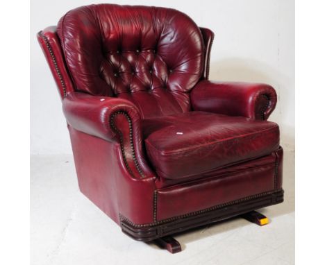 A vintage 20th century button back chesterfield fireside lounge armchair. Having an oval button back cushioned backrest, into