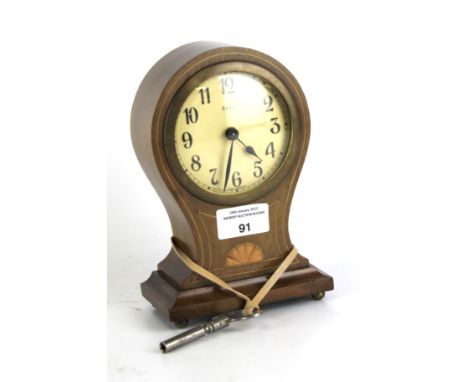 An Austrian mantel clock. The dial with Arabic numerals, within an inlaid mahogany case, raised on bun feet, with platform es